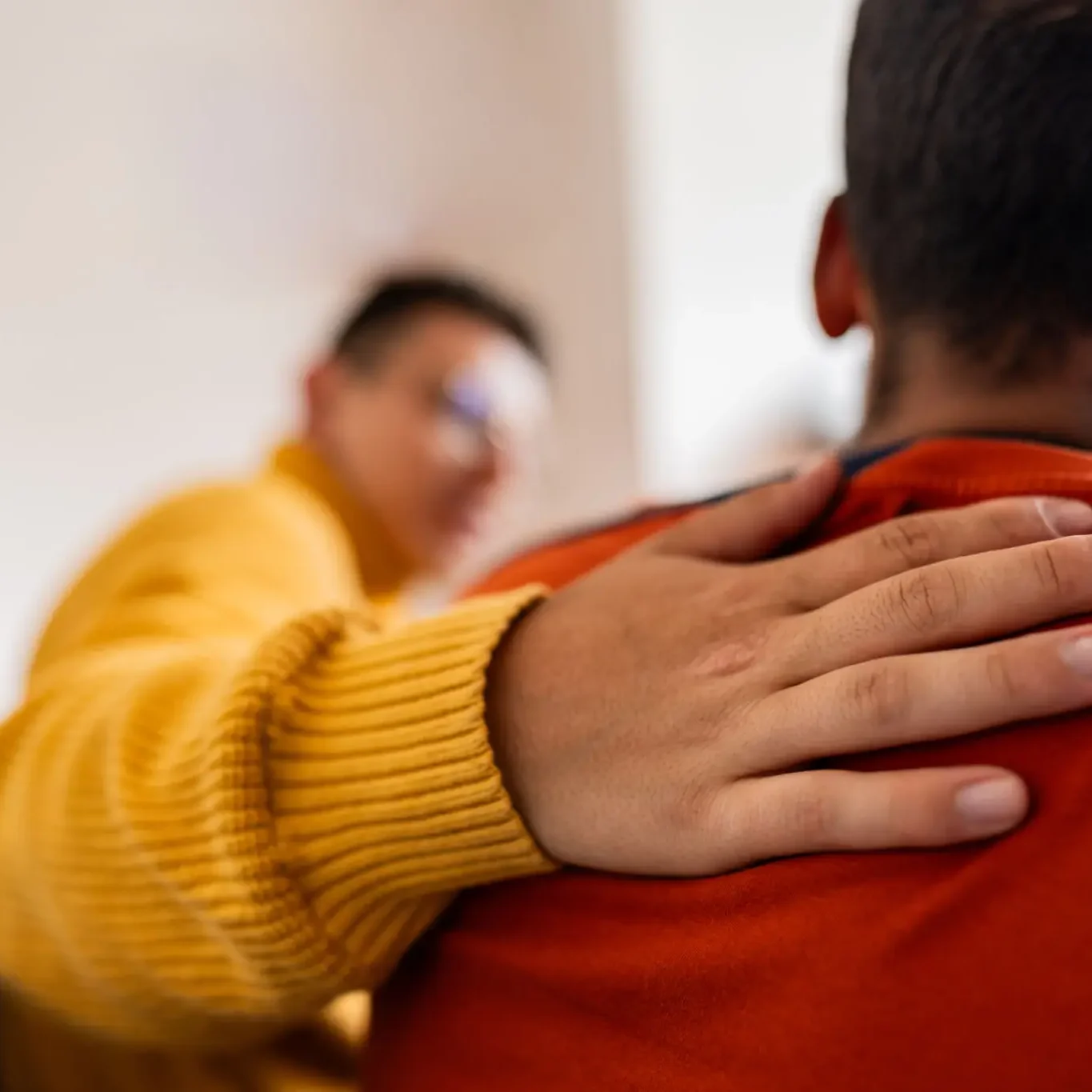 A comforting hand on someone's shoulder showing support.