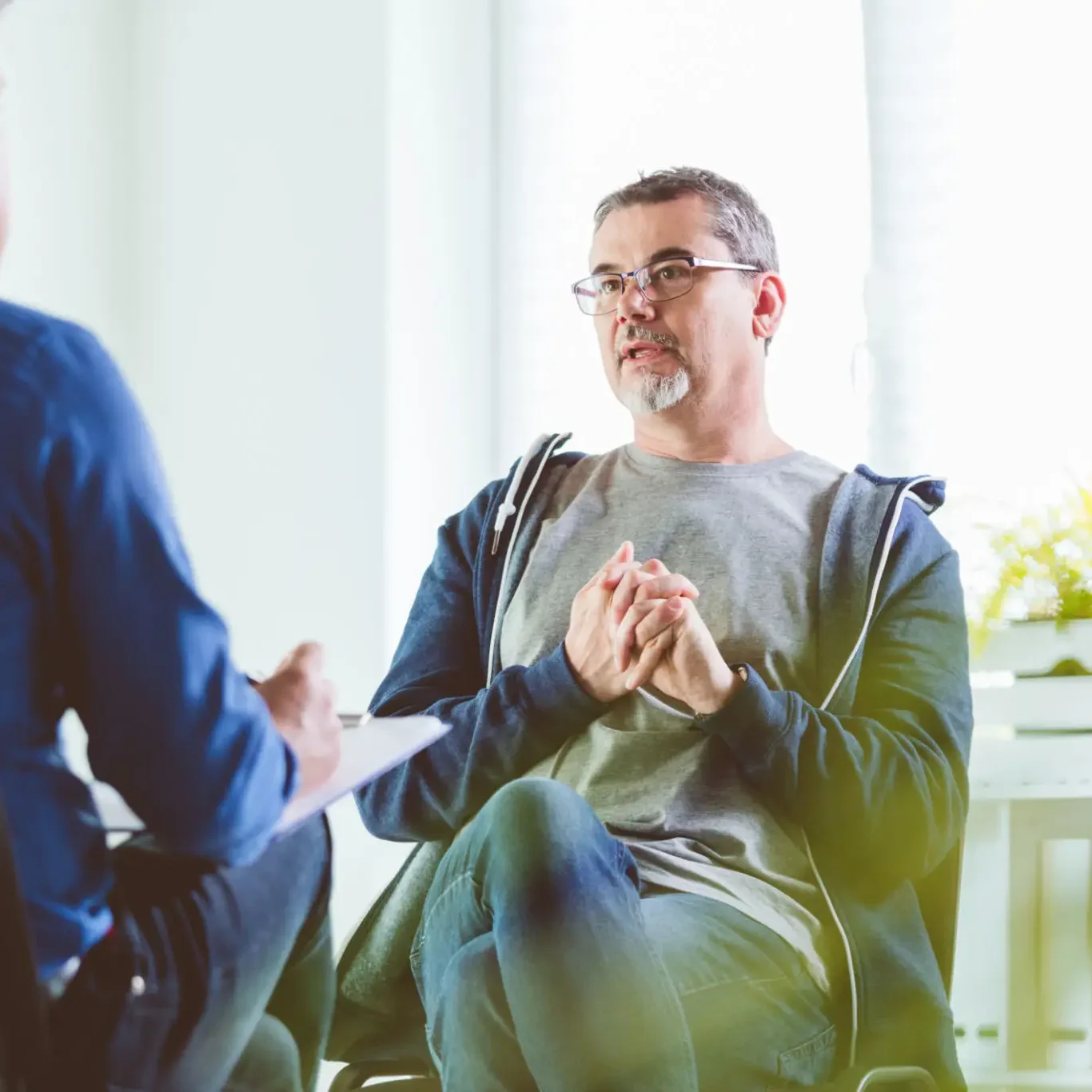 Man in glasses attentively listening during a conversation.